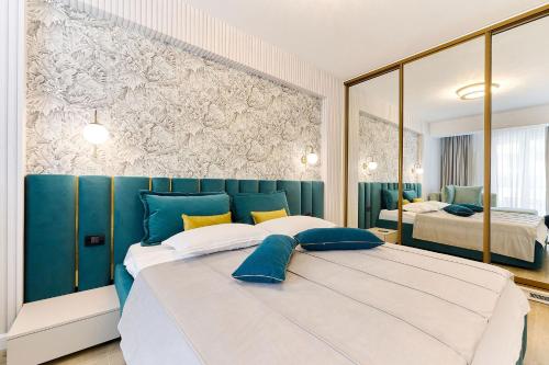 a blue and white bedroom with a large bed at Tropical Apartament - Spa&Pool in Infinity Beach Resort in Mamaia