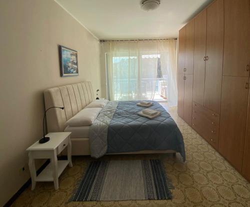 a bedroom with a bed and a table and a window at Marconi Lake View in Baveno
