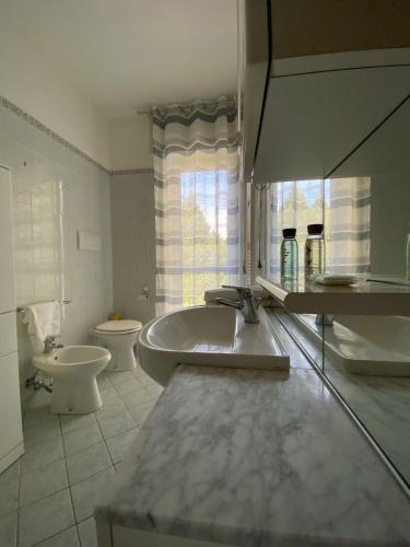 a bathroom with a tub and a toilet and a sink at Marconi Lake View in Baveno