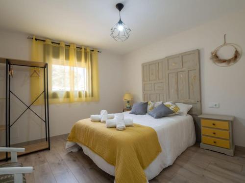 a bedroom with a large bed with a yellow blanket at Casa Rural El Moradel Añon in Añón