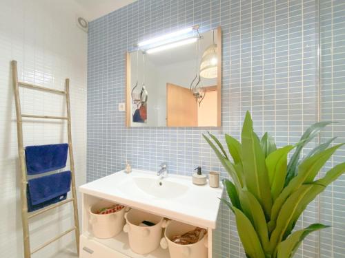 uma casa de banho com um lavatório, um espelho e uma planta em Cozy Retreat for Couples in Burgau no Burgau