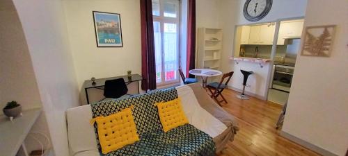 ein Wohnzimmer mit einem Sofa und einer Küche in der Unterkunft Le Gambetta T2 Cosy Hypercentre WIFI Fibre avec parking in Pau