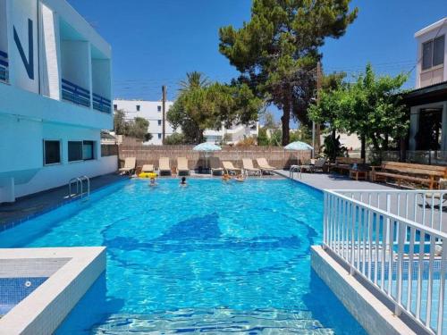 - une piscine d'eau bleue dans un bâtiment dans l'établissement NEREUS HOTEL By IMH Europe Travel and Tours, à Paphos