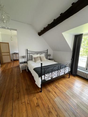 Château de Villefargeau في Villefargeau: غرفة نوم بسرير وارضية خشبية