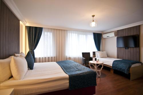 um quarto de hotel com uma cama, uma cadeira e uma mesa em Genius Hotel Istanbul em Istambul