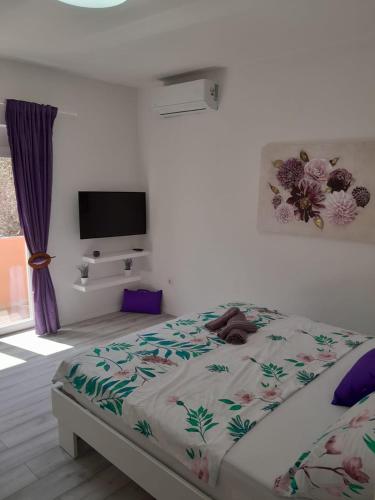 a bedroom with a bed and a tv on a wall at Dani in Zadar