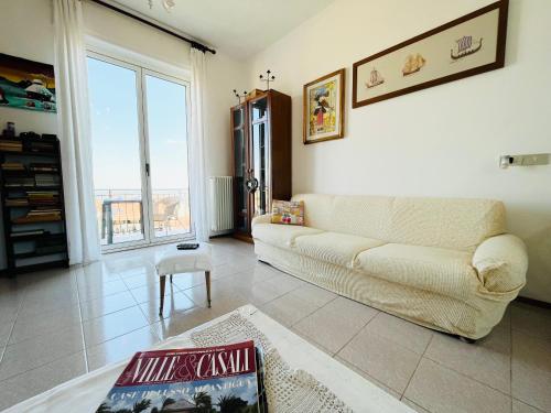 sala de estar con sofá y ventana grande en Casa vacanze con vista panoramica, en Frassinello Olivola