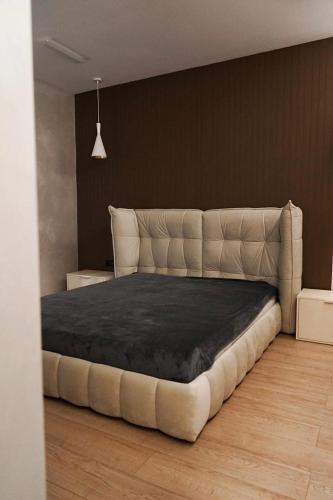 a bedroom with a large bed with a leather headboard at NL group apartments in Kolomiya