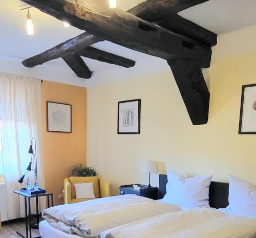 a bedroom with two beds and a ceiling with beams at Hotel Alte Post in Dannenberg