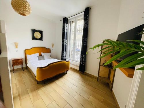 sypialnia z łóżkiem i dużym oknem w obiekcie Les appartements du village w Nancy