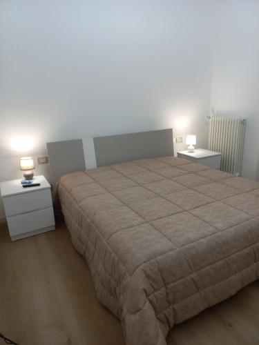 1 dormitorio con 1 cama grande y 2 mesitas de noche en La Casa degli Angeli, en Matera