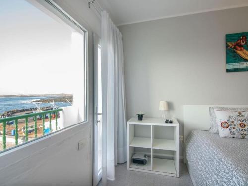 1 dormitorio con cama y vistas a la playa en Weybeach3 ocean frontline,sea view,private terrace, en La Santa