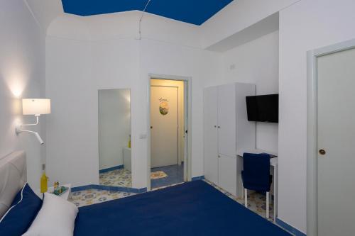 a bedroom with a blue bed and a yellow door at Locanda Costa D'Amalfi in Amalfi