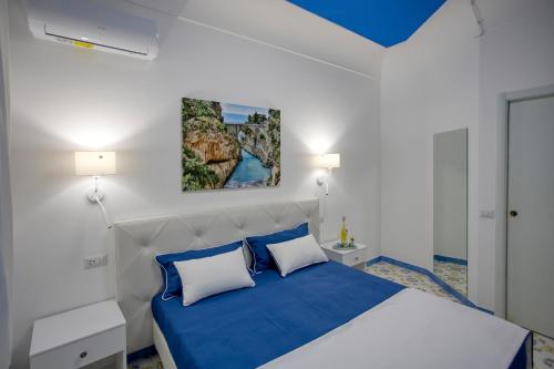 a bedroom with a blue and white bed with two pillows at Locanda Costa D'Amalfi in Amalfi