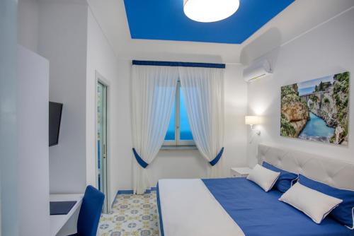 a bedroom with a bed with a blue ceiling at Locanda Costa D'Amalfi in Amalfi