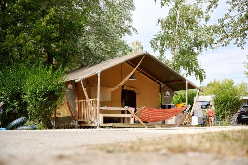 a house with a hammock in front of it at Glamping Lac d'Orient in Mesnil-Saint-Père
