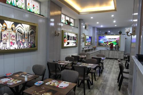 イスタンブールにあるKaya Madrid Hotelのテーブルと椅子のあるレストラン、バー