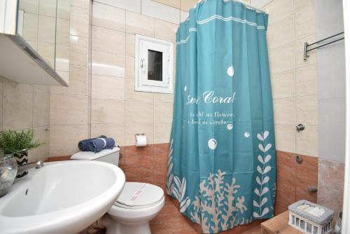 ein Bad mit einem WC und einem Duschvorhang in der Unterkunft Like Your Home Apartment Thessaloniki in Thessaloniki