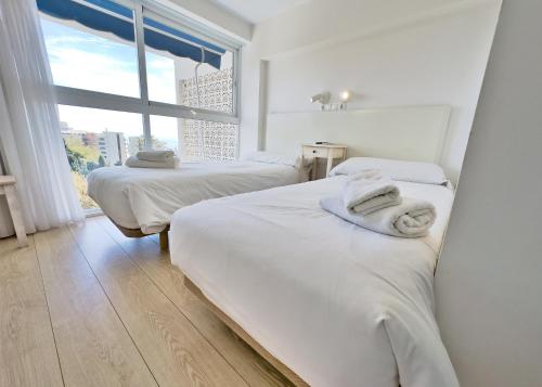 deux lits dans une chambre avec une fenêtre dans l'établissement Skol 514 East Facing Duplex Apartment with Sea Views, à Marbella
