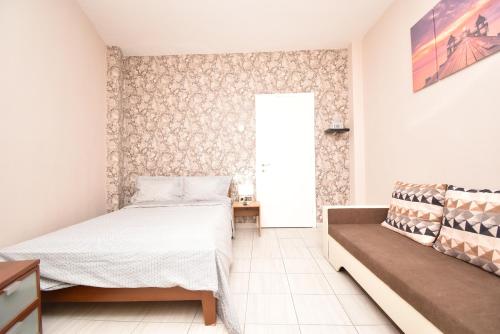 ein Schlafzimmer mit einem Bett und einem Sofa in der Unterkunft Like Your Home Apartment Thessaloniki in Thessaloniki
