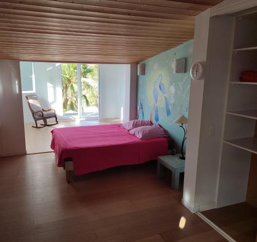 um quarto com uma cama com um cobertor rosa em Villa Porticcio - piscine , belle vue mer proche des plages em Porticcio