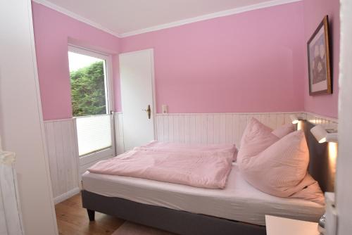 a bedroom with pink walls and a bed with white pillows at fewo1846 - Pauline - zauberhafte Wohnung für 2 Personen mit Terrasse und Garten in Glücksburg