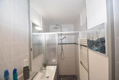 a white bathroom with a shower and a sink at fewo1846 - Pauline - zauberhafte Wohnung für 2 Personen mit Terrasse und Garten in Glücksburg