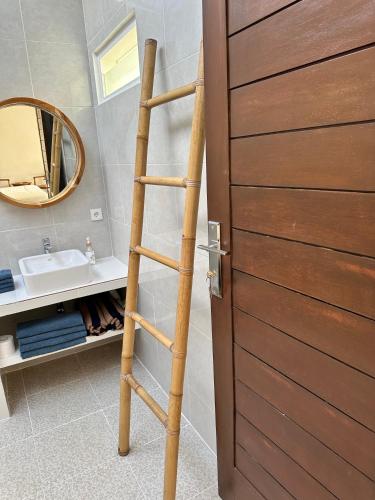 a wooden ladder in a bathroom next to a mirror at Asri Villas Bingin in Uluwatu