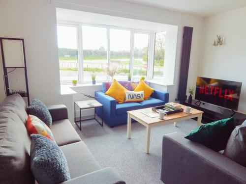 a living room with a blue couch and a tv at Lancaster House in Lincoln