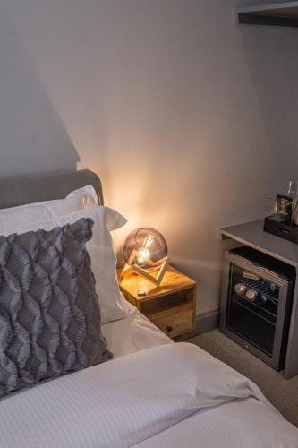 a bedroom with a bed and a clock on a table at The Arran, St Andrews in St. Andrews