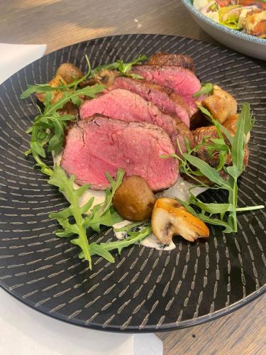 a plate of meat and vegetables on a table at Home Suite Hotels Rosebank in Johannesburg