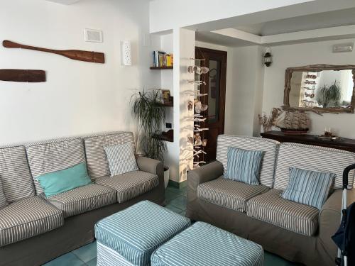 un soggiorno con 2 divani e uno sgabello di B&B Residence Eco Del Mare a Palinuro