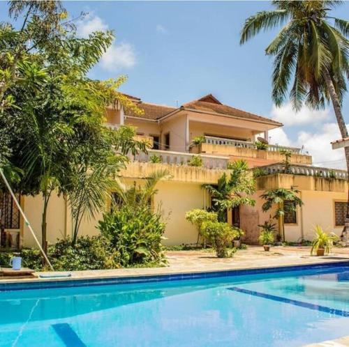 een villa met een zwembad voor een huis bij A cosy Mustard Haven-Shanzu in Mombasa