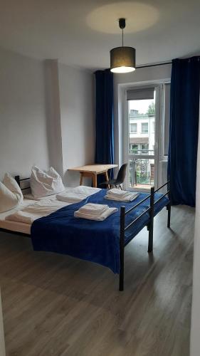 een slaapkamer met een bed, een tafel en een raam bij Apartament 3 pokoje z balkonem Asklepios in Świnoujście