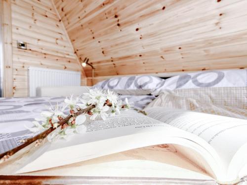 an open book on a bed with flowers on it at Bective Mill Glamping & Camping in Bective