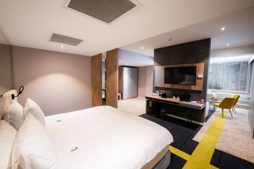 a hotel room with a large bed and a television at Mandachi Hotel & SPA in Suceava