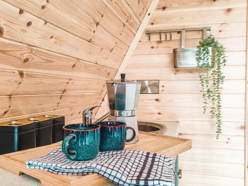 uma cozinha com duas canecas num balcão numa pequena casa em Bective Mill Glamping & Camping 