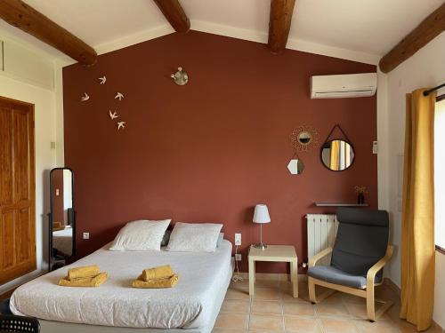 a bedroom with a bed and a chair at Les Célestins - Studios indépendants in Carpentras