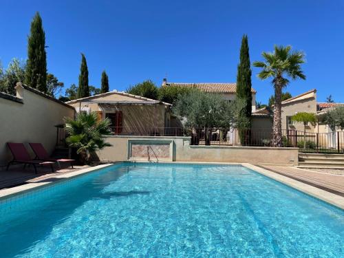 - une piscine d'eau bleue dans la cour dans l'établissement Les Célestins - Studios indépendants, à Carpentras