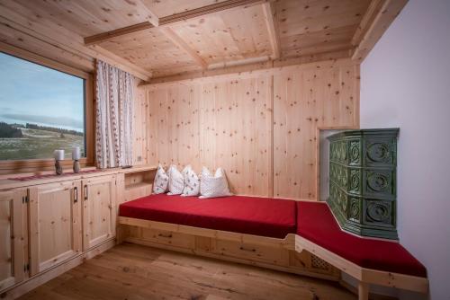 um quarto com uma cama vermelha num quarto de madeira em Au Hochalm Chalet em Söll