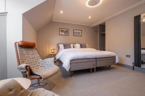 a bedroom with a king sized bed and a chair at The Arran, St Andrews in St Andrews