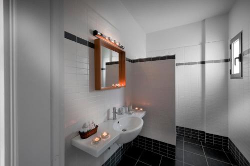 uma casa de banho branca com um lavatório e um espelho em Superior Villa Lino em Skiros