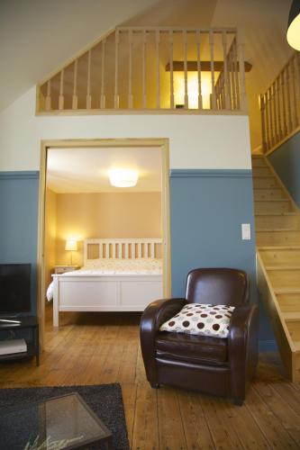 une chambre avec un lit et une chaise dans l'établissement Le grenier du Faouët, à Le Faouët