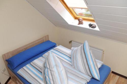 een bed in een kleine kamer met een dakraam en een bed sidx sidx bij Nanninga Ferienwohnung Nanni 