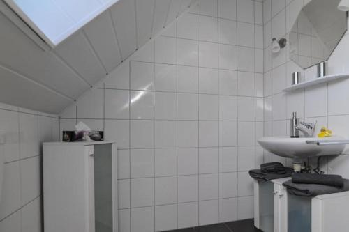 een witte badkamer met een wastafel en een spiegel bij Nanninga Ferienwohnung Nanni 