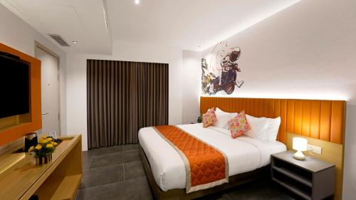 a hotel room with a bed and a flat screen tv at City Keys Bangalore By Bestinn Leisure in Bengaluru