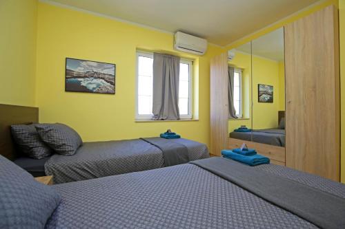 a room with two beds and a couch and a mirror at Villa Tea in Donje Polje
