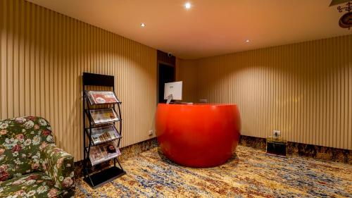 a room with a red couch and a book shelf at City Keys Bangalore By Bestinn Leisure in Bengaluru