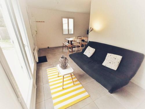 a living room with a couch and a table at Maison Rose-Trémière avec jardin clos - Plage à 500m in Chaucre
