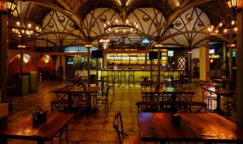 Hotel City Keys By Rivido, Electronic City في بانغالور: مطعم فارغ بطاولات وكراسي خشبية